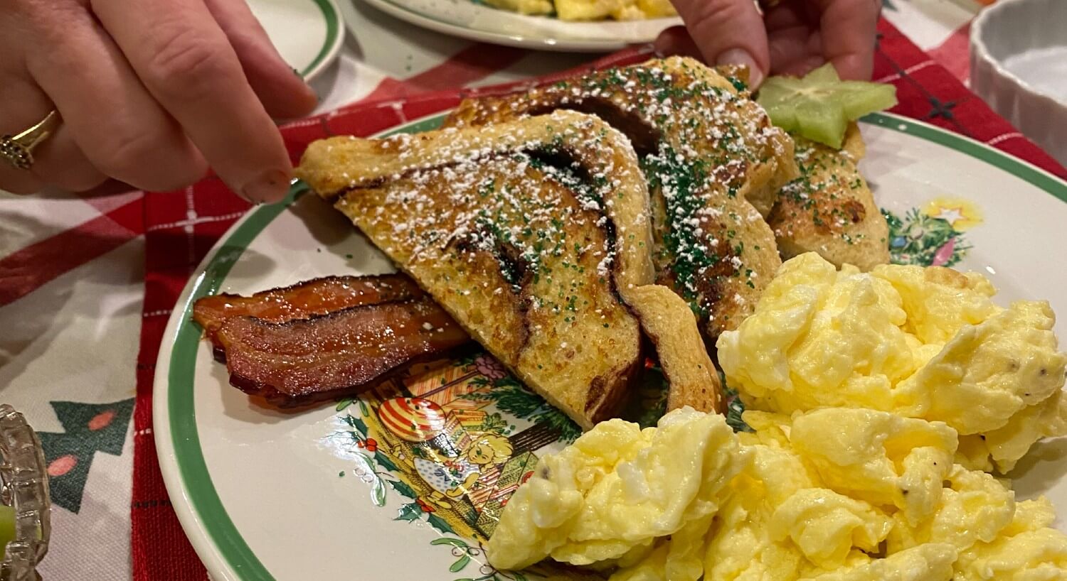 A decorative breakfast plate with French toast, bacon and scrambled eggs